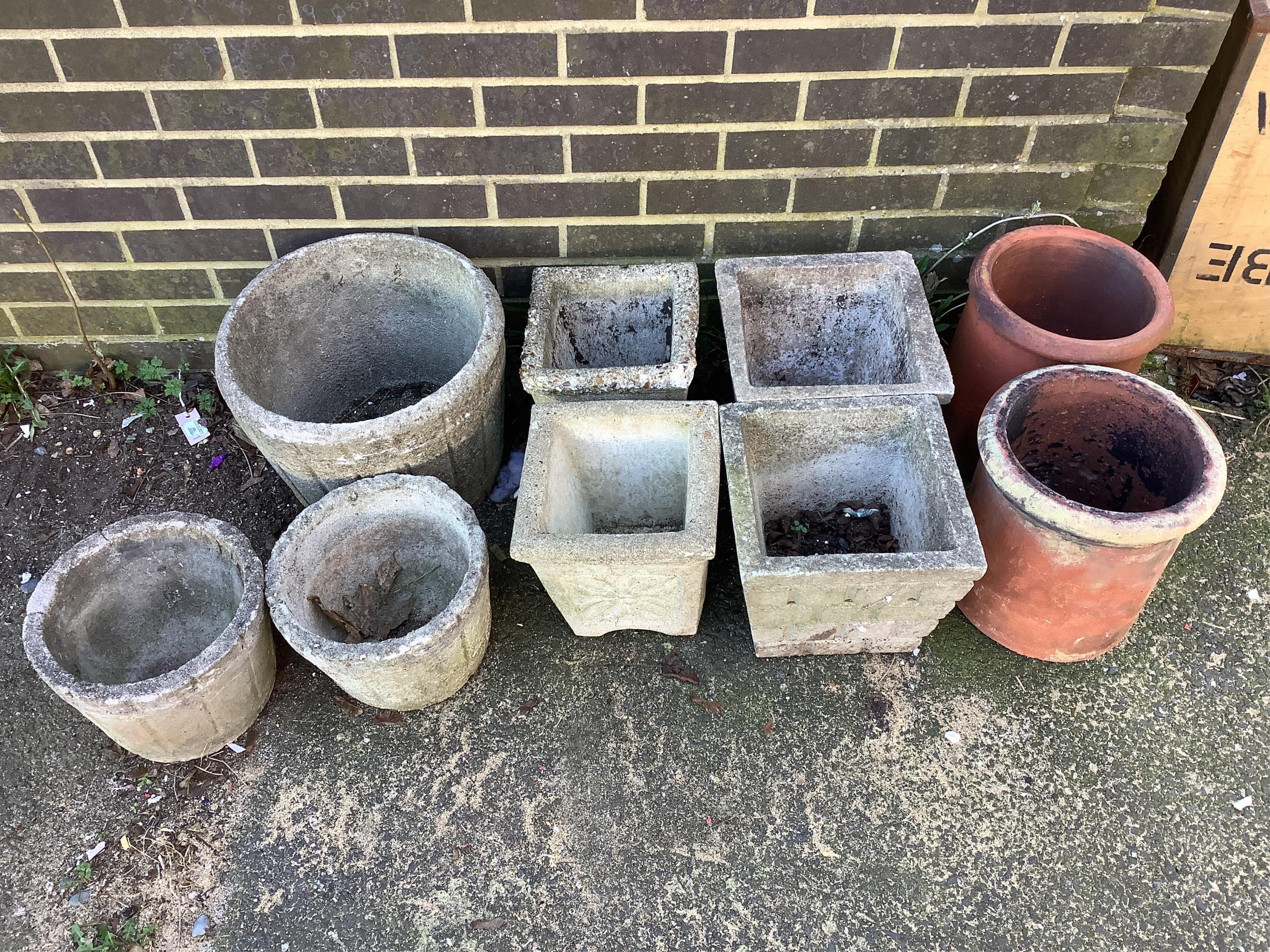 Seven reconstituted stone garden planters and a pair of terracotta forcers, largest diameter 40cm. Condition